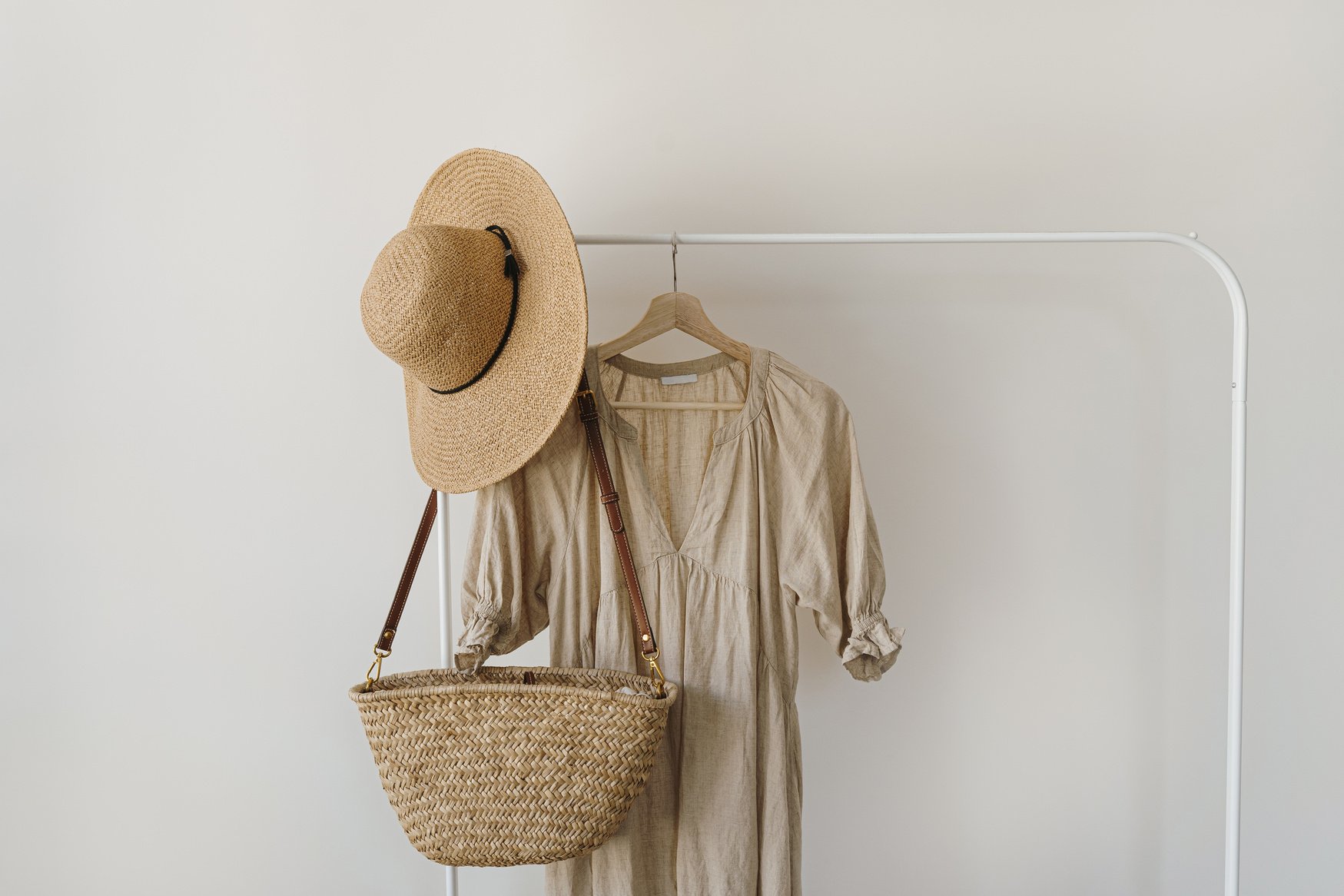 Rattan Bag, Hat and Nude Dress Hanging on the Rack